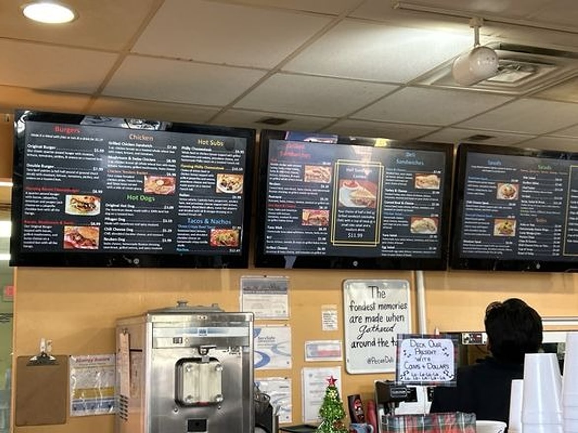 Digital menu boards above the counter at Pecan St. Station